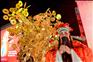 1月9日，在马来西亚吉隆坡，一名装扮成财神爷的演员与“富贵黄金树”合影。