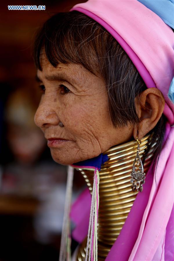 A Padaung woman with brass rings around her neck sits at her gift shop in Panpet Village, Demoso Township, Kayah State, Myanmar, April 11, 2016.