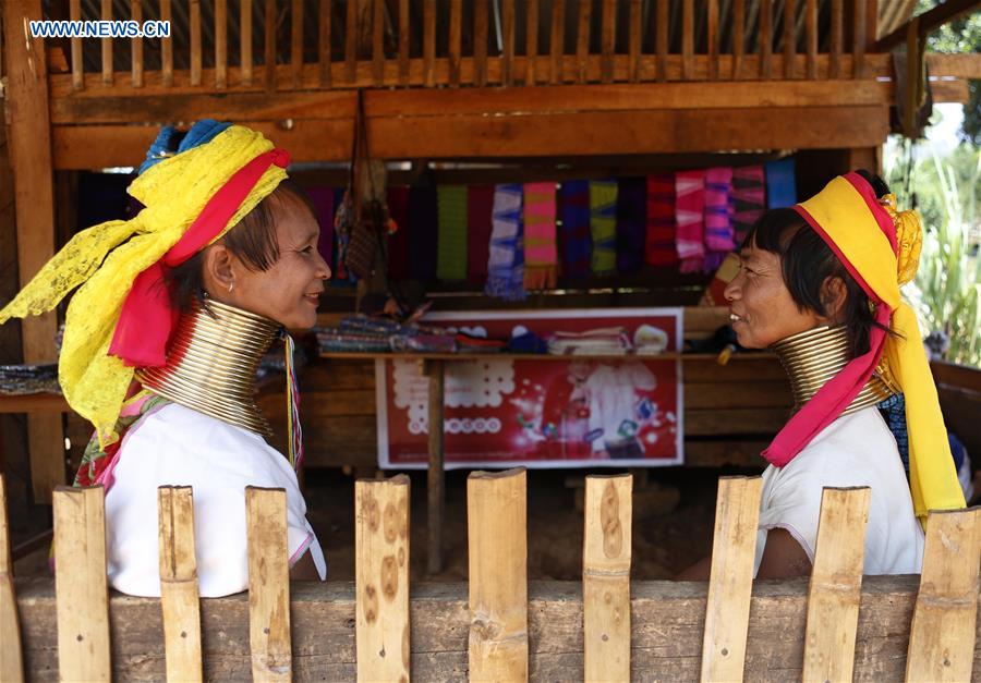 Padaung women with brass rings around their necks chat at a gift shop in Panpet Village, Demoso Township, Kayah State, Myanmar, April 11, 2016.