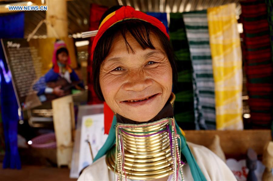 A Padaung woman with brass rings around her neck smiles as she stands at her gift shop in Panpet Village, Demoso Township, Kayah State, Myanmar, April 11, 2016.