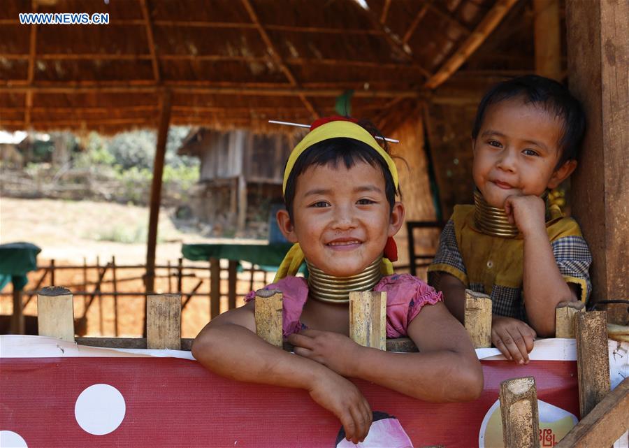 Padaung children with brass rings around their necks sit at a gift shop in Panpet Village, Demoso Township, Kayah State, Myanmar, April 11, 2016. 