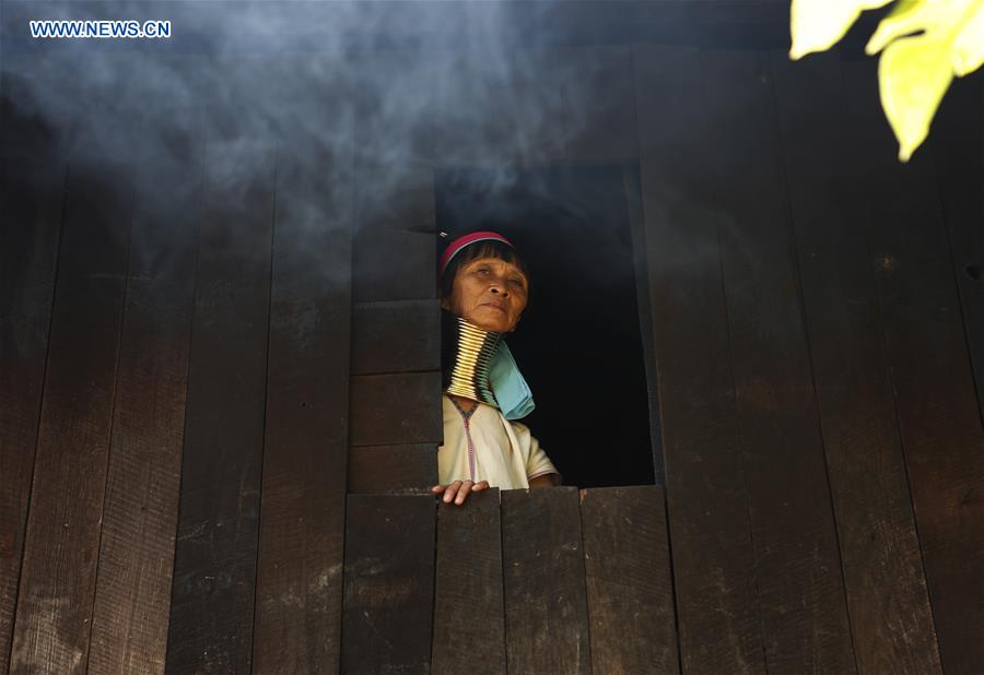 A Padaung woman with brass rings around her neck looks out of the window in Panpet Village, Demoso Township, Kayah State, Myanmar, April 11, 2016. 