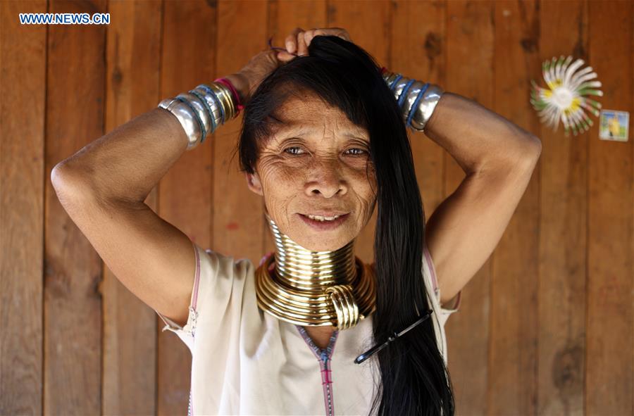 A Padaung woman with brass rings around her neck combs her hair at her home in Panpet Village, Demoso Township, Kayah State, Myanmar, April 11, 2016.