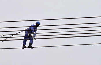 Electrical engineers do maintenance work on electricity tower in Kuwait